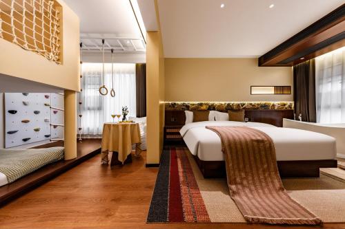 a hotel room with a bed and a table at MiLO Hearth米罗设计民宿 张家界天门山索道店 in Zhangjiajie