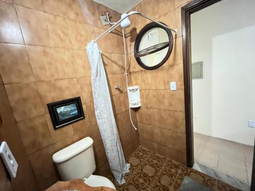 a bathroom with a shower with a toilet and a mirror at Loft para casal em prédio familiar 3,5km do centro histórico in Petrópolis