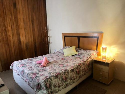 a bedroom with a bed with a pink stuffed animal on it at Loft para casal em prédio familiar 3,5km do centro histórico in Petrópolis