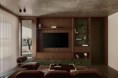 un soggiorno con un divano e una televisione di Arrawarra Beach House ad Arrawarra