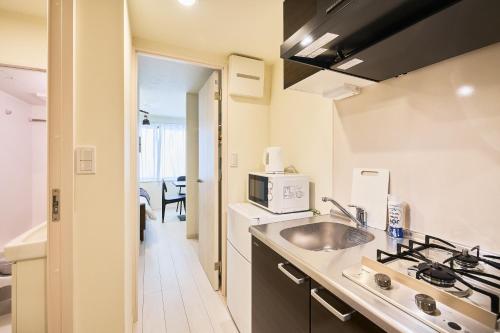 a kitchen with a sink and a microwave at Reberty Haneda in Tokyo