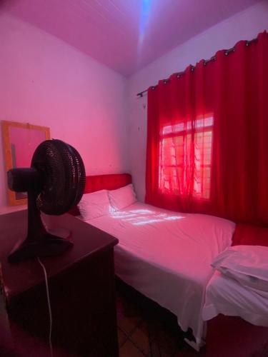 a room with two beds and a red light at Quarto para temporada in Goiânia