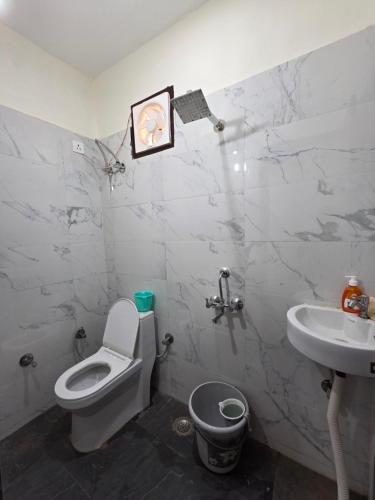 a bathroom with a toilet and a sink at The Cozy Nest in Gurgaon