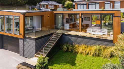 a modern house with a deck and a patio at Renard Retreat in Akaroa