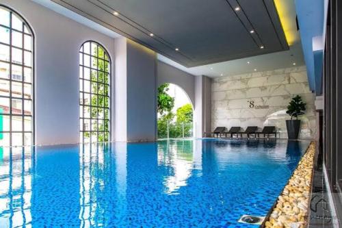 a large swimming pool with blue water in a building at The8collaction in Bangkok