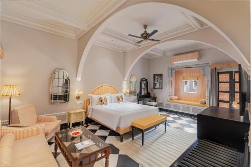 a bedroom with a bed and a living room at lebua Udaipur Daulatgarh in Udaipur