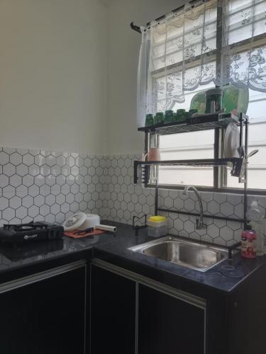 a kitchen counter with a sink and a window at 571 Seroja Homestay in Sungai Petani