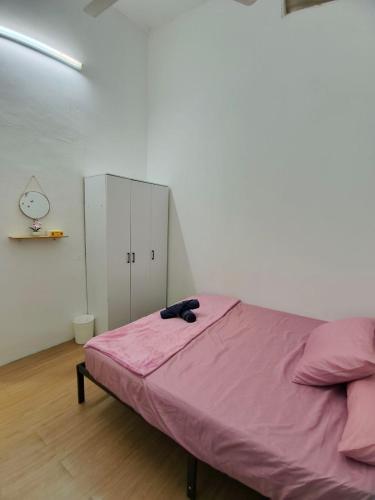 a bed in a room with a pink blanket on it at 571 Seroja Homestay in Sungai Petani