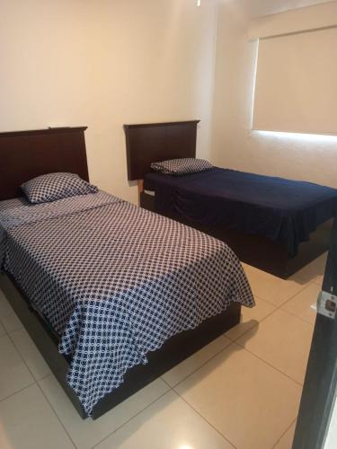 a room with two beds and a window at Villa en Terrasol Diamante in Acapulco