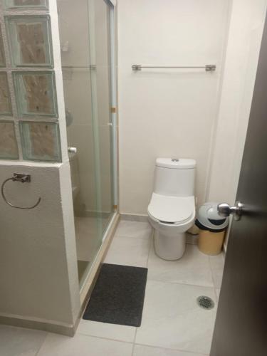 a bathroom with a toilet and a glass shower at Villa en Terrasol Diamante in Acapulco