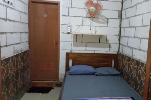 a small room with a bed and a brick wall at Penginapan Joko Samudro in Baron