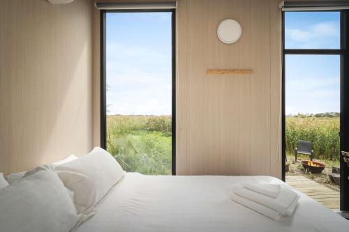 a bedroom with a bed and a large window at Revillaging Project by Tiny Away in Boneo