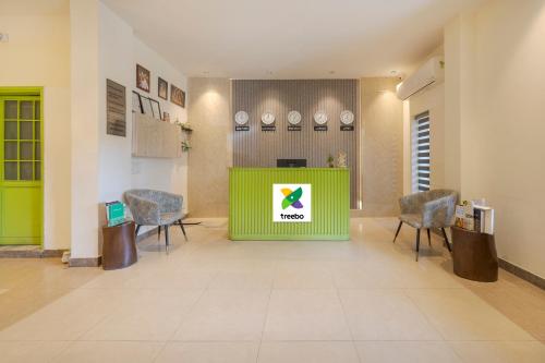 a lobby with a green counter and chairs at Treebo Ace Luxe in New Delhi