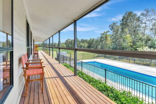 a balcony with two benches and a swimming pool at Shiraz Vineyard Estate in Pokolbin