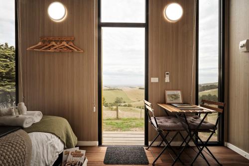 a bedroom with a bed and a desk and a window at Sunset Hill by Tiny Away in Dollar