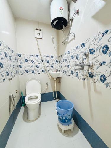 a bathroom with a toilet and a sink and a bucket at Shri Homestay 800m from kashi vishwanath in Varanasi