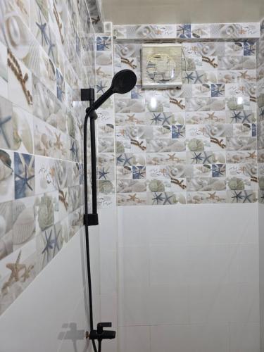 a floor lamp in a bathroom with a tile wall at La Leona Homestay in Hernani