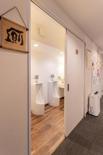 a bathroom with four urinals and two sinks at Saikou in Osaka