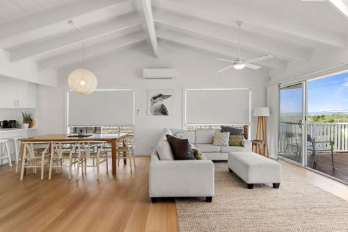 a living room with a table and a dining room at Peppertree Jervis Bay Pet Friendly Beachfront with Sea Views in Callala Beach