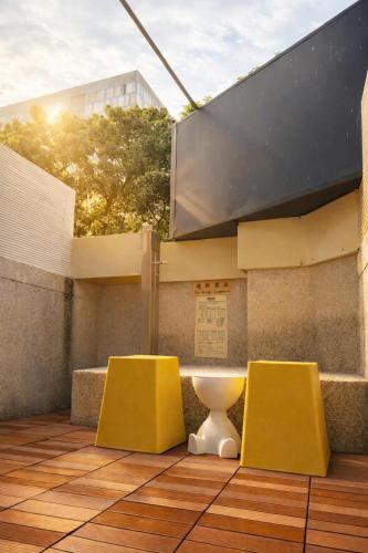 a bathroom with two yellow chairs and a toilet at 逢甲25行館Fengjia 25 Hotel in Taichung