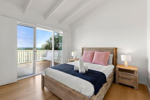 a bedroom with a large bed and a balcony at Peppertree Jervis Bay Pet Friendly Beachfront with Sea Views in Callala Beach