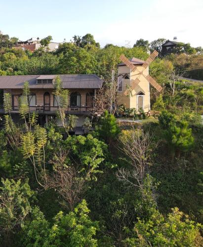 a house on top of a hill with trees at Peaceful Waterfall Homestay - Nhà Bên Thác in Hoat