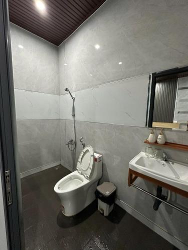 a bathroom with a toilet and a sink at Muối Hồng Homestay in Ấp Tân Hà