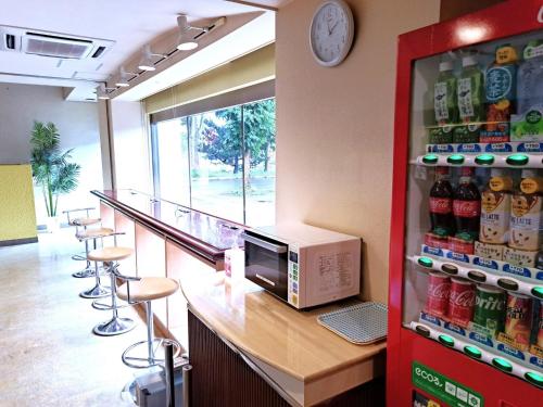 a bar with a microwave and some bar stools at Hotel Tetora Higashimuroran - Vacation STAY 75821v in Muroran