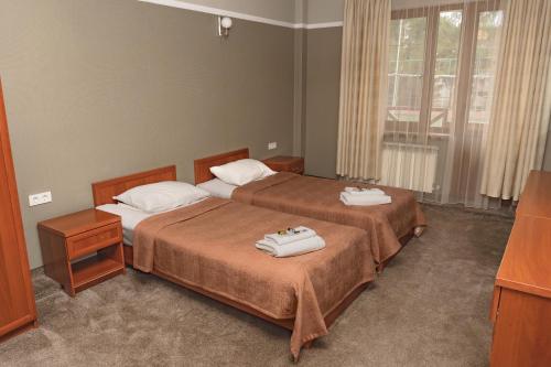 a bedroom with two beds with towels on them at Alpen Ville in Almaty