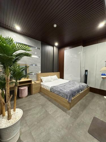 a bedroom with a bed and a potted plant at Muối Hồng Homestay in Ấp Tân Hà