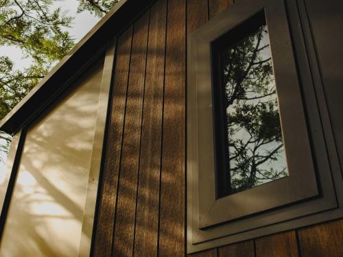 a window on the side of a house at Sunset Tiny House at Bluebush Estate X by Tiny Away in Rothbury
