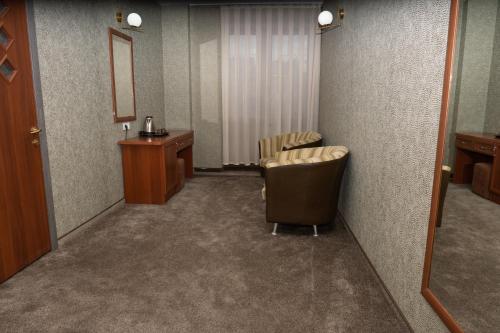 a waiting room with a chair and a sink at Alpen Ville in Almaty