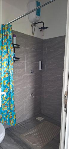 a shower with a shower curtain in a bathroom at Homely studio Apartment 2 in Mombasa