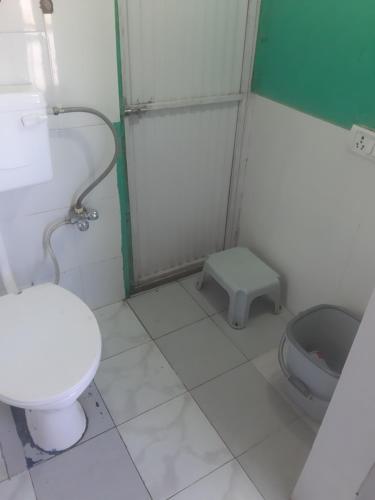 a small bathroom with a toilet and a shower at Rahul Residency Homestay- Couple & Family friendly- 'prime location- Easy access to Mall Rd- WiFi- Smart TV - Kitchen- City view in Solan