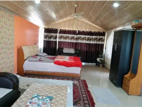 a bedroom with a bed and a couch in it at Rahul Residency Homestay- Couple & Family friendly- 'prime location- Easy access to Mall Rd- WiFi- Smart TV - Kitchen- City view in Solan