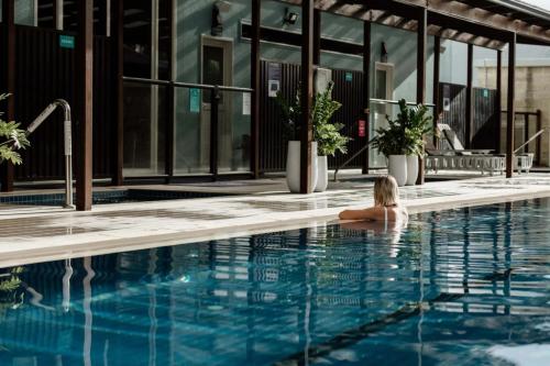 a woman sitting in the swimming pool at a hotel at Tasman Holiday Parks - North Star in Hastings Point