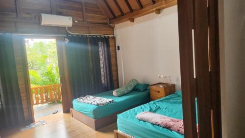 a bedroom with two beds and a window with a balcony at Qinoz Villaz in Kedungwaru