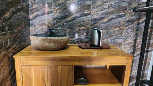 a bathroom with a sink and a bowl on a wooden table at Qinoz Villaz in Kedungwaru