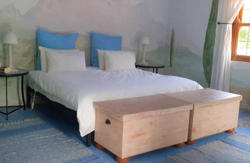 a bedroom with a large bed with a wooden box on it at Gecko Cottage at Artemis in Franschhoek