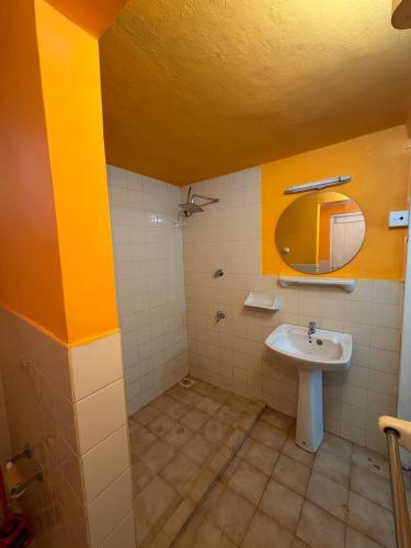 a bathroom with a sink and a mirror at Alex s Cottage in Kandy
