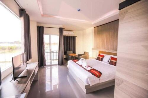 a bedroom with a large bed and a television in it at Chiang Rai Airport Hotel in Ban Fang Min