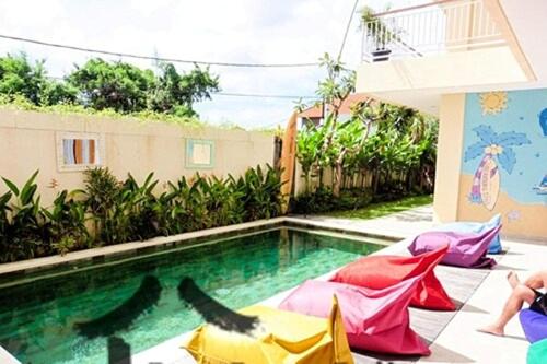 a swimming pool with colorful umbrellas in a backyard at Home 21 Bali in Sanur