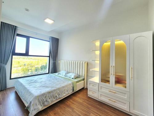a bedroom with a bed with a dresser and a window at Swanbay - Rice's House in Nhơn Trạch