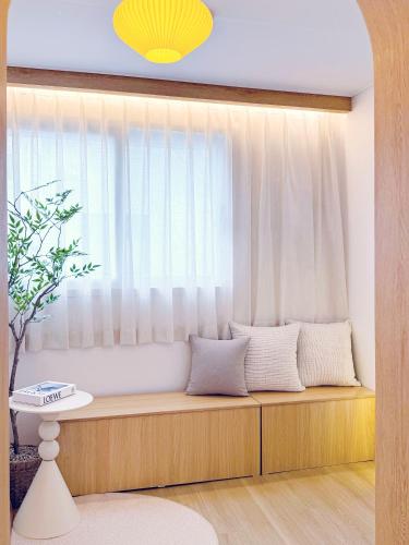 a bench in a room with a window at Euljiro Central 3BR Stay in Seoul