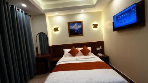 sypialnia z łóżkiem i telewizorem na ścianie w obiekcie Hotel AD w Katmandu