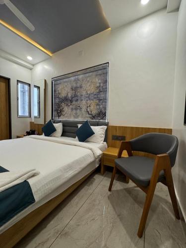 a bedroom with a large bed and a chair at The Premier, Dwarka in Dwarka