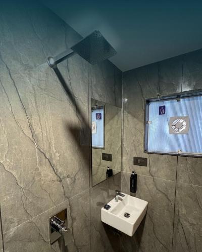 a bathroom with a sink and a shower at The Premier, Dwarka in Dwarka