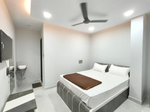 a bedroom with a bed and a ceiling fan at Hotel Rudra in Wākal