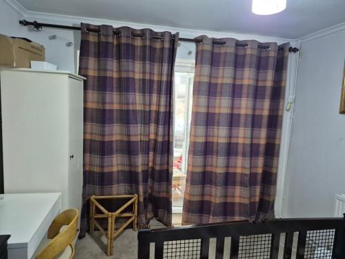 a curtain in a room with a window at The Garden view Nook in Ash