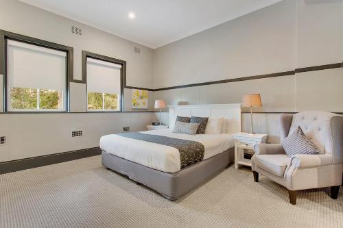 a large bedroom with a bed and a chair at CH Boutique Hotel, an Ascend Collection Hotel in Tamworth